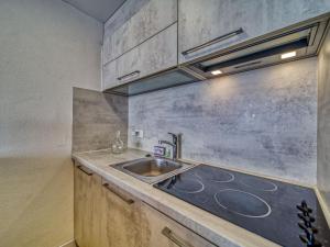 Il comprend une cuisine équipée d'un évier et d'une cuisinière. dans l'établissement Apartment Le Sérac-10 by Interhome, à Val Thorens