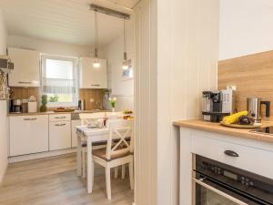 a kitchen with white cabinets and a table with chairs at Ostseeklang in Zingst
