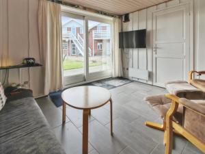 a living room with a table and a couch at Apartment Gertruda - 2-3km from the sea in Western Jutland by Interhome in Havneby