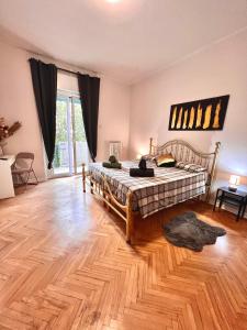 1 dormitorio con 1 cama y suelo de madera en Residence Locchi, en Trieste