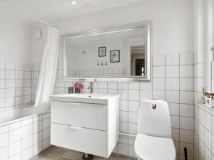 a white bathroom with a sink and a toilet at Holiday Home Ortrud - 200m from the sea in NW Jutland by Interhome in Skagen