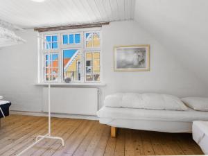 a white bedroom with a bed and a window at Holiday Home Ortrud - 200m from the sea in NW Jutland by Interhome in Skagen
