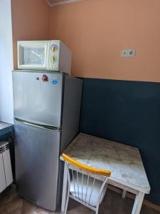 Il comprend une petite cuisine avec une petite table et un réfrigérateur. dans l'établissement Apartament motel, à Chişinău