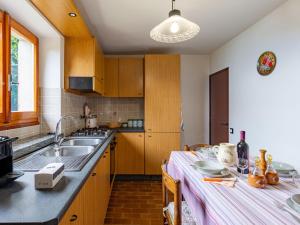 cocina con armarios de madera, fregadero y mesa en Holiday Home Munt del Nana by Interhome, en Plesio