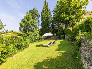 a group of benches with an umbrella in a yard at Holiday Home Ridaldi by Interhome in Greve in Chianti