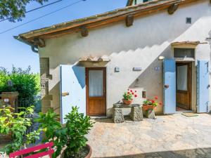 una pequeña casa con puertas azules y una mesa en Holiday Home Ridaldi by Interhome, en Greve in Chianti