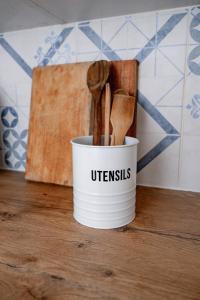 a white bucket of utensils sitting on a table at Shilo Beach Home - Loadshedding Free in Wilderness