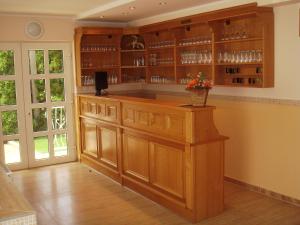 a kitchen with a bar with wooden cabinets at Green Guesthouse Balatonfüred in Balatonfüred