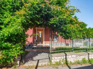 a small red house with a fence and trees at Apartment Villa Michelle by Interhome in Bardino Nuovo