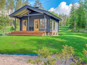 una casa pequeña con una terraza en el césped en Holiday Home Paloranta by Interhome, en Kuhmo