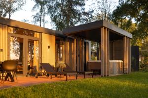 een modern huis met een patio en gras bij Zicht op Twente - Spa lodges in Markelo