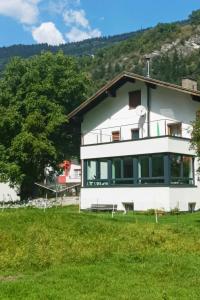 ein großes weißes Haus mit einem Baum davor in der Unterkunft Apartment Apart Hof Achenrainer by Interhome in Landeck