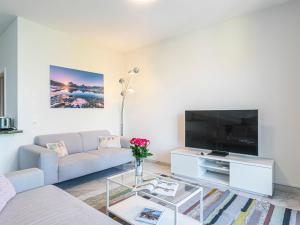 a living room with a couch and a tv at Apartment Le Jazz by Interhome in Montreux