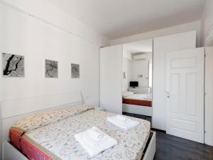 - une chambre blanche avec un lit et un miroir dans l'établissement Apartment Pratolina by Interhome, à Rome