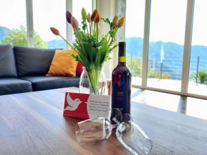 una botella de vino y copas en una mesa en Holiday Home Casa Carina by Interhome, en Carona