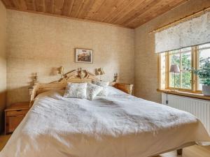 a bedroom with a large bed and a window at Chalet Korpstigen Älgen - DAN075 by Interhome in Sälen