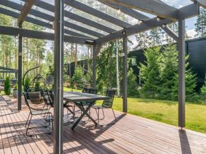een terras met een tafel en stoelen bij Holiday Home Villa murdoc by Interhome in Vierumäki