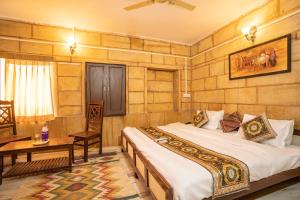 a bedroom with two beds and a table in it at Hotel Classic Jaisalmer in Jaisalmer