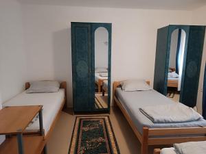 a room with two beds and a mirror and a table at Mota Apartment in Jablanica
