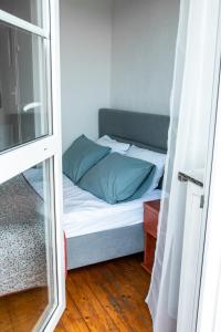 - łóżko z niebieskimi poduszkami w niewielkim pokoju w obiekcie Willa JODŁA Wisła w Wiśle