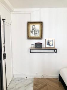 a room with a white wall with a shelf and a picture at Home Sweet Home Paris Montmartre in Paris