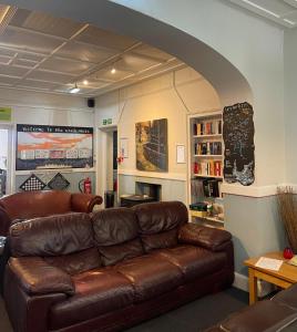 uma sala de estar com um sofá de couro castanho e um arco em YHA Windermere em Troutbeck
