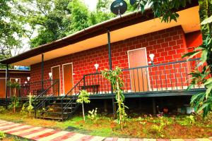 una casa di mattoni rossi con una scala di fronte di The Kille Torna Resort a Pune