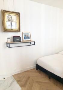 a bedroom with a bed and a picture on the wall at Home Sweet Home Paris Montmartre in Paris
