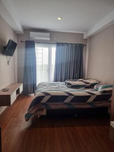een slaapkamer met een bed en een raam bij skyview apartemen by gowsleep in Sunggal