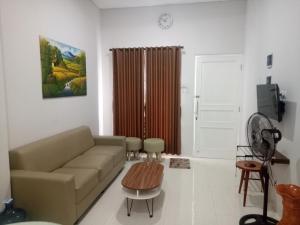 ein Wohnzimmer mit einem Sofa und einem Tisch in der Unterkunft Omah Bondi Family Homestay by FH Stay in Yogyakarta