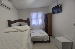 Ein Bett oder Betten in einem Zimmer der Unterkunft Pousada Kasarão Praia Grande Ubatuba