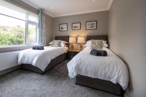 2 Betten in einem Schlafzimmer mit Fenster in der Unterkunft Stylish 2 bed pet-friendly coastal retreat in Braunton