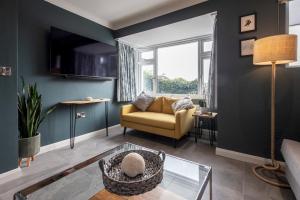 ein Wohnzimmer mit einem Sofa und einem Fenster in der Unterkunft Stylish 2 bed pet-friendly coastal retreat in Braunton
