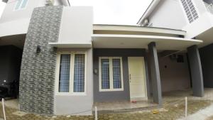 ein weißes Haus mit gelber Tür in der Unterkunft Omah Bondi Family Homestay by FH Stay in Yogyakarta
