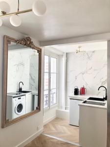 a kitchen with a mirror and a washing machine at Home Sweet Home Paris Montmartre in Paris