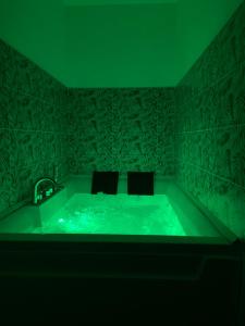 ein grünes Bad mit einer Badewanne mit 2 Stühlen in der Unterkunft Vesuvio 65 in Ercolano