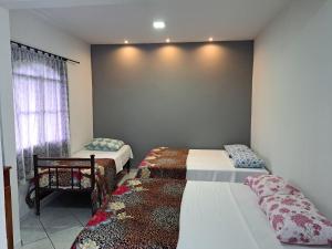 a bedroom with two beds and a window at Recanto São Romão in Nova Friburgo