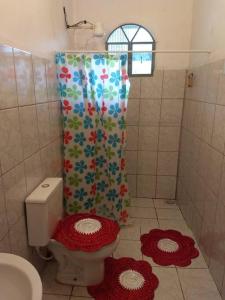 a bathroom with a toilet and a shower curtain at Recanto São Romão in Nova Friburgo