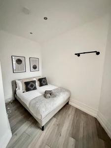 um quarto com uma cama com um gato deitado sobre ela em Modern 1-Bedroom Apartments in Shoreditch, Old Street em Londres