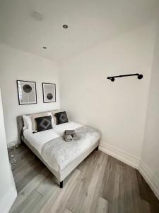 a bedroom with a bed with a cat laying on it at Modern 1-Bedroom Apartments in Shoreditch, Old Street in London