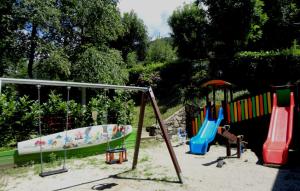 un gruppo di attrezzature per giochi in un recinto di sabbia di Campeggio Punta di Crabbia a Pettenasco