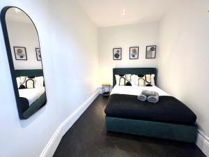 um quarto com uma cama e um espelho grande em Modern 1-Bedroom Apartments in Shoreditch, Old Street em Londres