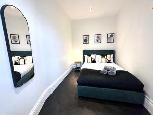 a bedroom with a bed and a large mirror at Modern 1-Bedroom Apartments in Shoreditch, Old Street in London