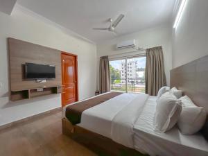 a bedroom with a large bed and a television at Hotel Elite By Agira Hotels-Free Airport Pickup or Drop in Yelahanka