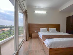 - une chambre avec un lit et une grande fenêtre dans l'établissement Hotel Elite By Agira Hotels-Free Airport Pickup or Drop, à Yelahanka