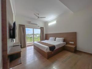 a bedroom with a bed and a large window at Hotel Elite By Agira Hotels-Free Airport Pickup or Drop in Yelahanka