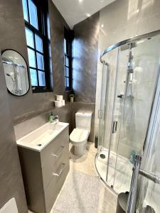 uma casa de banho com um WC, um lavatório e um chuveiro em Modern 1-Bedroom Apartments in Shoreditch, Old Street em Londres