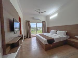 Habitación de hotel con cama y TV en Hotel Elite By Agira Hotels-Free Airport Pickup or Drop en Yelahanka