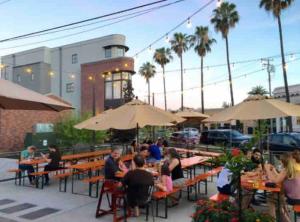 a group of people sitting at tables with umbrellas at Smart Spacious Artsy home near Midtown in Sacramento