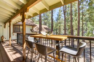 una terraza con mesa y sillas de madera en Big Bear Lake Retreat with Private Hot Tub!, en Big Bear Lake